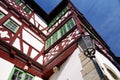 Neat half-timbered facade with red beams and green window frames and a street lamp
