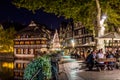 Half-timbered houses and sidewalk cafe at night in the Petite France historic quarter in Strasbourg, France Royalty Free Stock Photo