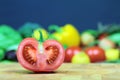 Half tomato on a chopping board and various vegetables