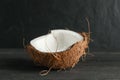 Half tropical coconut on wooden table against black background