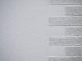 Half of the wall is finished with white plaster and the other half with white brick. Beautiful minimalistic wall Royalty Free Stock Photo