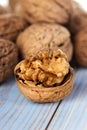 Half walnut kernel and whole walnuts on a wooden background