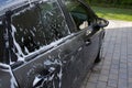 Half washed car with soap foam