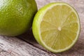 Half and whole fresh juicy lime on background wooden Royalty Free Stock Photo