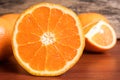 Half and whole fresh oranges on wooden table