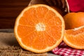 Half and whole fresh oranges on wooden table