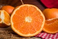 Half and whole fresh oranges on wooden table