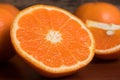 Half and whole fresh oranges on wooden table