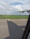 Half wing of an airplane and natural beauty, view from the window between landing time on the runway of the airport Royalty Free Stock Photo