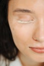 Half of woman face with pretty white vitiligo eyelashes and neat make up
