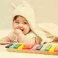 Half year baby girl playing with xylophone toy on blanket