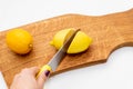 Fresh lemons a cutting board.A half of a yellow lemon on a wooden chopping board with a knife.Composition of delicious Royalty Free Stock Photo