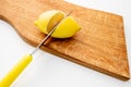 Fresh lemons a cutting board.A half of a yellow lemon on a wooden chopping board with a knife.Composition of delicious Royalty Free Stock Photo