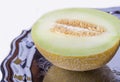 Half of yellow melon or cantaloupe on old tray in closeup Royalty Free Stock Photo