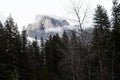 Halfdome With Snow And Cloudy Sky Through Trees Royalty Free Stock Photo