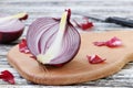Halfs of red onion is located on a wooden board on a table