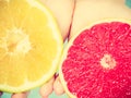 Halfs of yellow red grapefruit citrus fruit in human hands Royalty Free Stock Photo