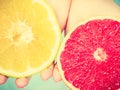 Halfs of yellow red grapefruit citrus fruit in human hands Royalty Free Stock Photo