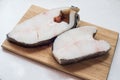 Halibut fish steak on a chopping Board