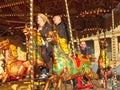 People riding on vintage carousel horses in the public square at Halifax piece hall west yorkshire
