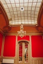 Hall in a mansion with a high domed ceiling. glass window with lattice texture. luxury chandelier. rich baroque interior