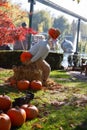 Halloween at the amusement park - a huge stuffed man with a pumpkin head is sitting on a haystack