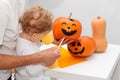 Halloween art craft with kids. Adorable toddler painting together with his dad. Family holiday preparation, party decor