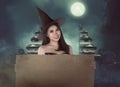 Halloween asian witch with hat holding blank paper