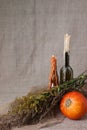 Halloween autumn still life. Pumpkin, candles in bottles, herbs. Light canvas background. e. Royalty Free Stock Photo