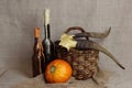 Halloween autumn still life. Pumpkin, candles in bottles, horns, herbs, basket. Black magic. Light canvas background.