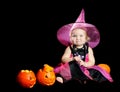 Halloween baby witch with a carved pumpkin