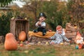 Halloween. Babys in a holidays costume sitting in kitchen-garden. Children in costumes of pirate and dalmatian dog