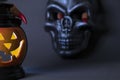 Halloween background. A close-up of glowing pumpkin with a carved face, with human scary fingers on top, with a black Royalty Free Stock Photo