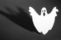 Halloween background concept. Funny ghost doing boo gesture and graphic shade behind on dark table Royalty Free Stock Photo