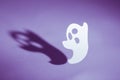 Halloween background concept. Handmade ghost and graphic shade, funny face, hard light on purple background Royalty Free Stock Photo