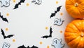 Halloween background with cute decorations and pumpkins on white table. Flat lay, top view, copy space. Halloween party invitation