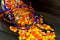 Halloween background frame consisting of a jar full of candy corn on a dark wooden table with a black table that you can personali Royalty Free Stock Photo