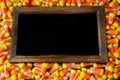 Halloween background frame consisting of a jar full of candy corn on a dark wooden table with a black table that you can personali Royalty Free Stock Photo