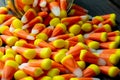 Halloween background frame consisting of a jar full of candy corn on a dark wooden table with a black table that you can personali Royalty Free Stock Photo