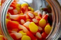 Halloween background frame consisting of a jar full of candy corn on a dark wooden table with a black table that you can personali Royalty Free Stock Photo