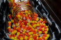 Halloween background frame consisting of a jar full of candy corn on a dark wooden table with a black table that you can personali Royalty Free Stock Photo