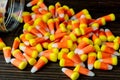 Halloween background frame consisting of a jar full of candy corn on a dark wooden table with a black table that you can personali Royalty Free Stock Photo