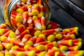 Halloween background frame consisting of a jar full of candy corn on a dark wooden table with a black table that you can personali Royalty Free Stock Photo