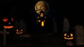 Halloween background with haunted house, ghost, bats and pumpkins, graves, at misty night spooky with fantastic big moon in sky.