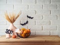 Halloween background with modern vase and decoration on wooden table over brick wall. Empty space for product display