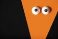 Halloween background, orange ghost with bulging eyes on a black