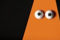 Halloween background, orange ghost with bulging eyes on a black