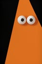 Halloween background, orange ghost with bulging eyes on a black