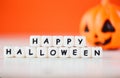 Halloween background orange with word blocks happy halloween decorations and pumpkin jack o lantern funny spooky on white wooden Royalty Free Stock Photo