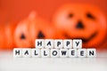 Halloween background orange with word blocks happy halloween decorations and pumpkin jack o lantern funny spooky on white wooden Royalty Free Stock Photo